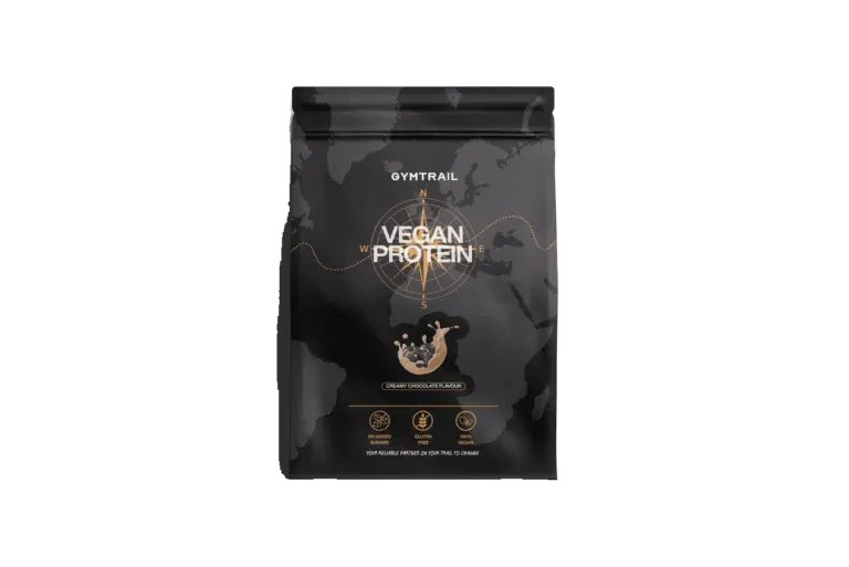 Eine schwarze Verpackung des veganen Proteinpulvers GYMTRAIL mit einem goldenen Kompassmotiv, einem Spritzer Schokolade und Symbolen, die den Nährwert des Pulvers hervorheben. Auf dem Etikett steht 